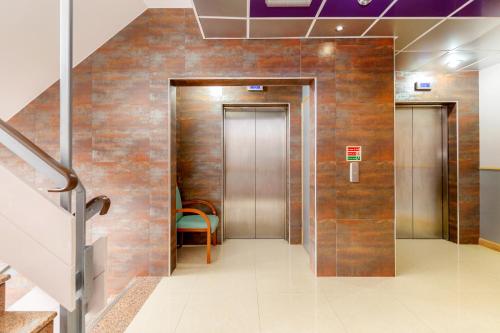 哈罗哈罗欧旅尊贵酒店的大楼内带两部电梯的走廊