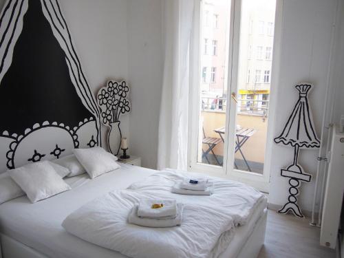 柏林鲍克思61艺术概念公寓旅舍的卧室配有白色的床和2条毛巾