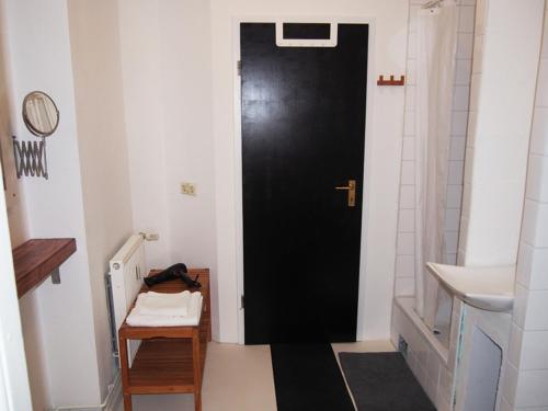 柏林鲍克思61艺术概念公寓旅舍的一个带水槽的浴室内的黑色门