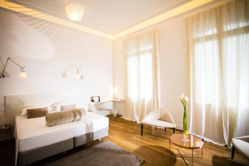 贝济耶贝济耶帕提库列酒店的白色的客厅配有沙发和桌子