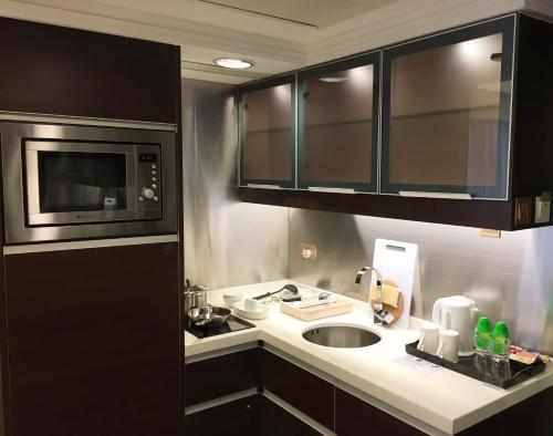 香港8度海逸酒店的厨房配有水槽和微波炉