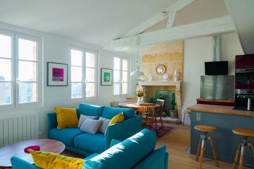 波尔多La Loge du 12的客厅配有蓝色的沙发和桌子