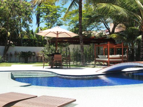 卡波布里奥雷坎托达帕萨杰姆精品酒店的一个带遮阳伞和桌椅的游泳池