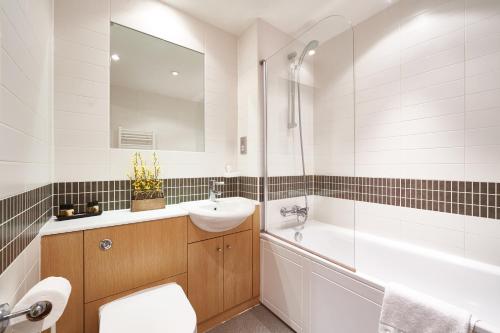 米尔顿凯恩斯ShortstayMK Vizion apartments, with free superfast wi-fi, parking, Sky sports and movies的浴室配有盥洗盆、卫生间和浴缸。