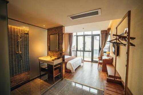 珠海喆·啡酒店珠海横琴长隆店的一间带一张床的卧室和一间带镜子的浴室