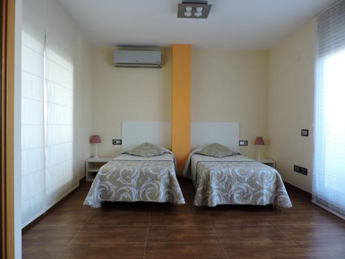 圣卡洛斯拉腊皮塔Apartament Ornis Duc Complexe Gorria的两张睡床彼此相邻,位于一个房间里