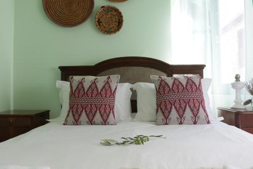 加藤德雷To Konatzi tis Marikas tzai tou Yianni的卧室配有白色床和红色及白色枕头