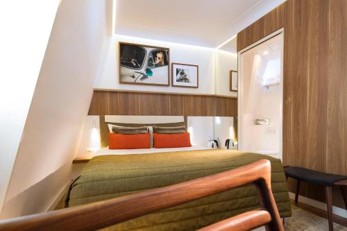 巴黎艾菲尔蒂雷纳酒店的一间卧室配有带橙色枕头的绿色床