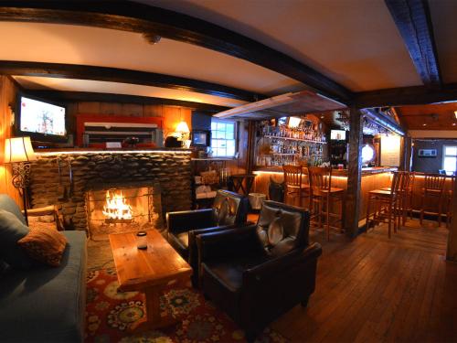 WaitsfieldHyde Away Inn的带壁炉的客厅和酒吧