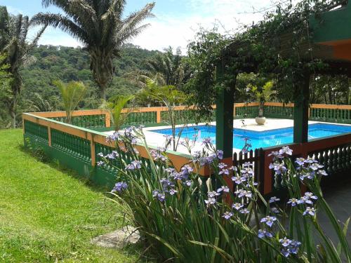 Turvo dos GóisPousada Recanto Águas Vivas的鲜花庭院中的游泳池