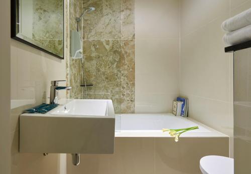新加坡Hotel 81 Gold的白色的浴室设有水槽和淋浴。