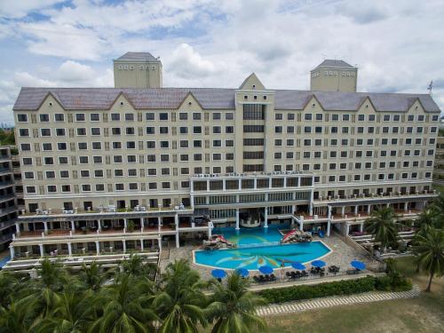 波德申迪克森港口克鲁斯天堂度假村的大型酒店,拥有大型游泳池和棕榈树