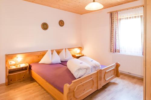 列兴Gasthof-Pension Waldfriede的一间卧室配有带白色枕头的木床