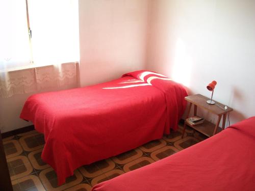 Montopoli in SabinaSweet Home的一间卧室配有两张带红色床单和桌子的床