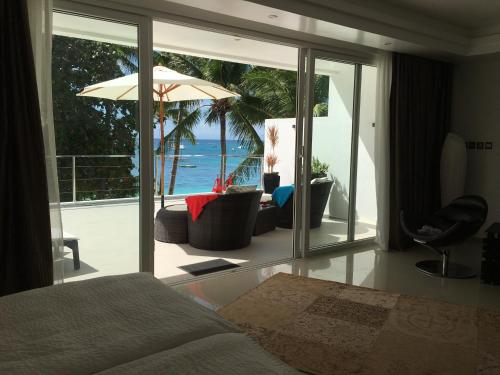 长滩岛日落海滩一室公寓式酒店的一间卧室配有一张床,享有海景