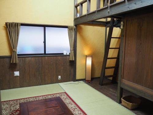 屋久岛朋友不眠旅馆的带双层床和梯子的客房