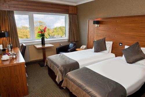 福尔柯克Park Hotel的酒店客房设有两张床和窗户。