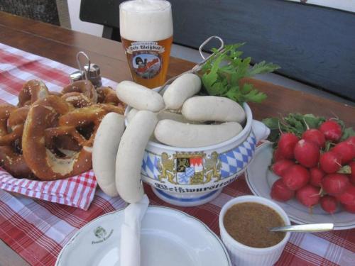 于贝尔塞Gasthof Hinterwirt的一张桌子,上面放着一碗热狗和啤酒