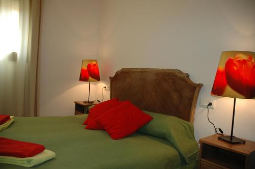 MontsonisCal Marroso的一间卧室配有一张带红色枕头的床和两盏灯。