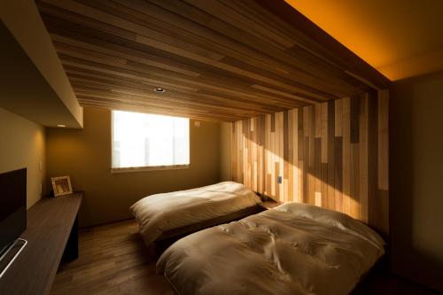 佐渡市毕奇酒店的小型客房 - 带2张床和窗户