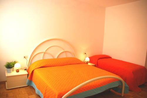 格拉多Casa Gaddi的一间卧室配有两张带橙色棉被的床