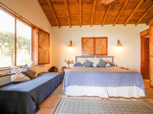 曼克拉Casitas Pacificas的一间带两张床的卧室,位于带窗户的房间内