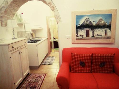洛科罗通多Trullo Sereno Angelo的客厅设有红色沙发,位于厨房内