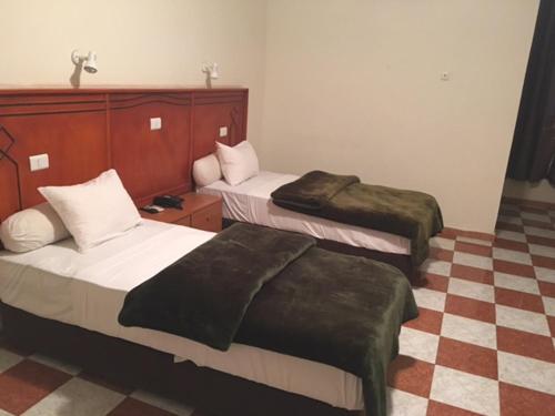 努瓦克肖特艾米拉酒店的酒店客房带两张床和一张 ⁇ 板