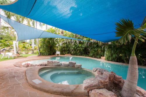库努纳拉艾芬豪度假酒店的一个带蓝伞和棕榈树的游泳池
