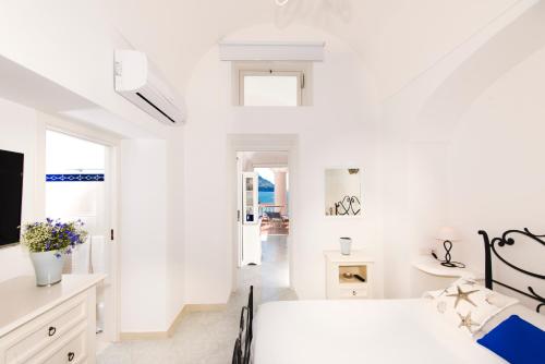 波西塔诺Exclusive Apartments Positano的一间白色卧室,配有床和电视