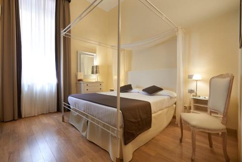 佛罗伦萨科西莫德美第奇酒店的一间卧室配有一张天蓬床和一把椅子
