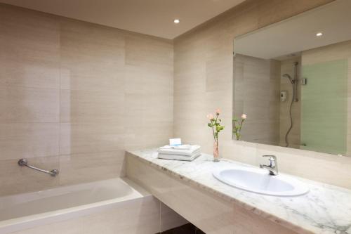 哈马马特TUI BLUE Manar的一间带水槽、浴缸和镜子的浴室