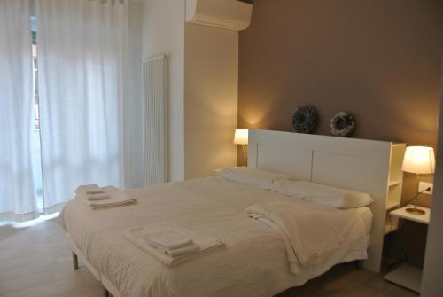 特伦托Piano B Apartment的卧室配有白色的床和2条毛巾