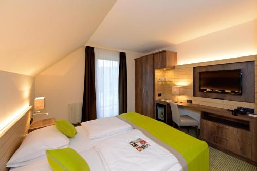 茨韦特尔施瓦茨阿尔姆酒店的酒店客房配有一张床、一张书桌和一台电视。