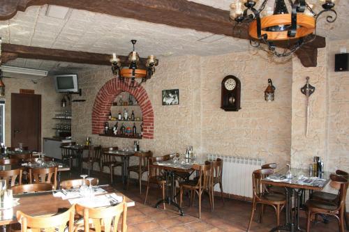 科尔内拉德罗布雷加特科尔内雅旅馆及餐厅的餐厅设有桌椅和墙上的时钟