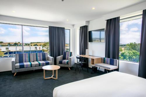 布莱克敦东克里克阿尔法酒店的酒店客房配有一张床、椅子和一张书桌