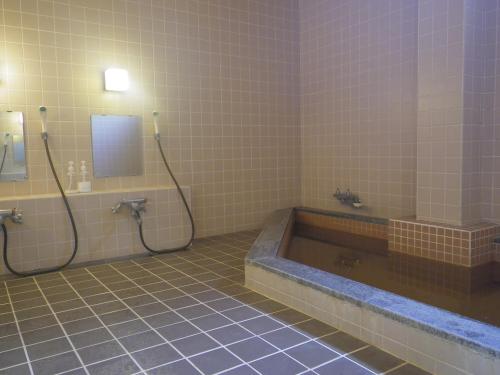 饭山市戸狩温泉村田旅馆的带浴缸和盥洗盆的浴室