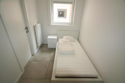 尼乌波特Dolce Vita Nieuwpoort的一间白色的小房间,配有床和窗户