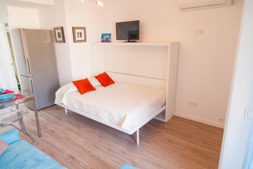 贝纳尔马德纳Agata 501的一间卧室配有一张带两个橙色枕头的床