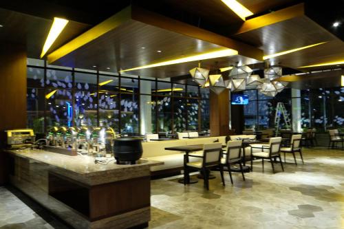 沙马林达三马林达市中心酒店的餐厅设有酒吧,配有桌椅