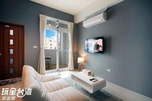 台东鐵花國小民宿的客厅配有白色沙发和电视