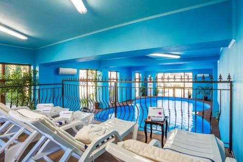 特罗扬蒙搭涅特罗央庄园酒店的一间设有白色椅子的房间和一个游泳池