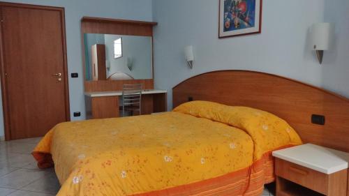 米兰2000酒店的一间卧室配有一张带黄色毯子的大床