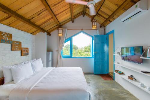 会安生活海滩别墅的卧室设有一张白色大床和一扇窗户。