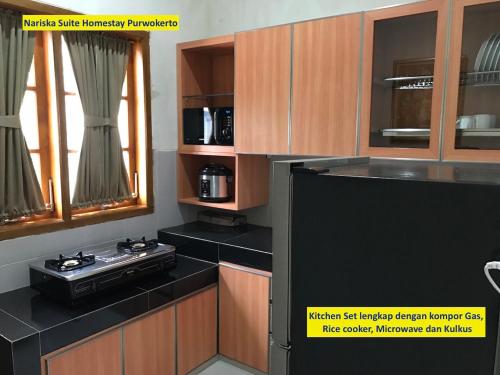 普禾加多普洱沃克托那里斯卡套房民宿的厨房配有木制橱柜和黑色台面