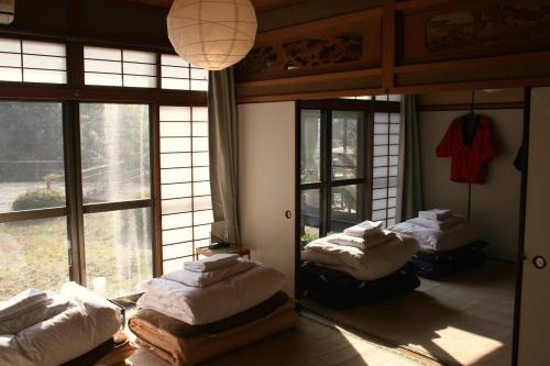 广岛广岛88号楼旅馆的带窗户的客房内设有三张床。