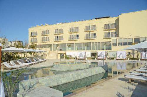 拉纳卡E-Hotel Larnaca Resort & Spa的一座带游泳池和椅子的酒店和一座建筑