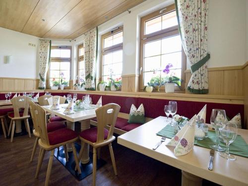 蒂蒂湖-新城Gasthaus Schweizerhof的餐厅设有白色的桌椅和窗户。