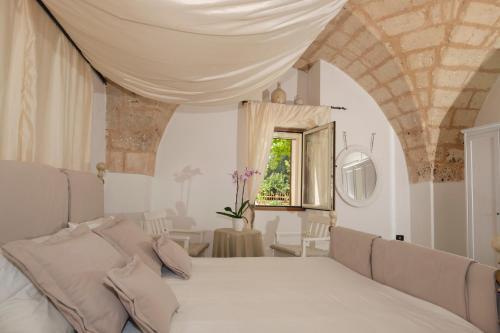 圣维托诺曼Masseria Pagliamonte的卧室配有白色的床和窗户。