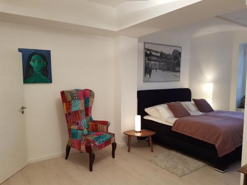 伍珀塔尔Business Apartment Briller Viertel的一间卧室配有一张床和一把椅子